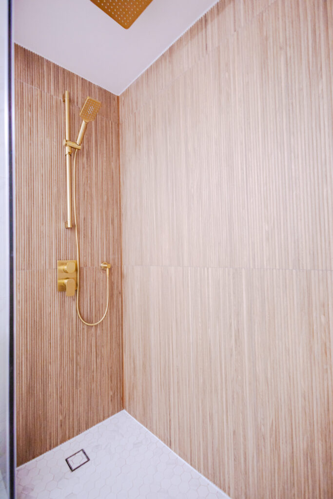 Walk-in shower with a rain head, handheld sprayer and recessed niche for a spa feel