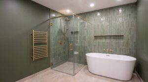 Green bathroom renovation in Richmond Hill with a walk-in glass shower, freestanding tub, zellige feature wall and brushed gold heated towel rail