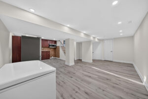 Open basement rec room with boxed structural columns and recessed lighting